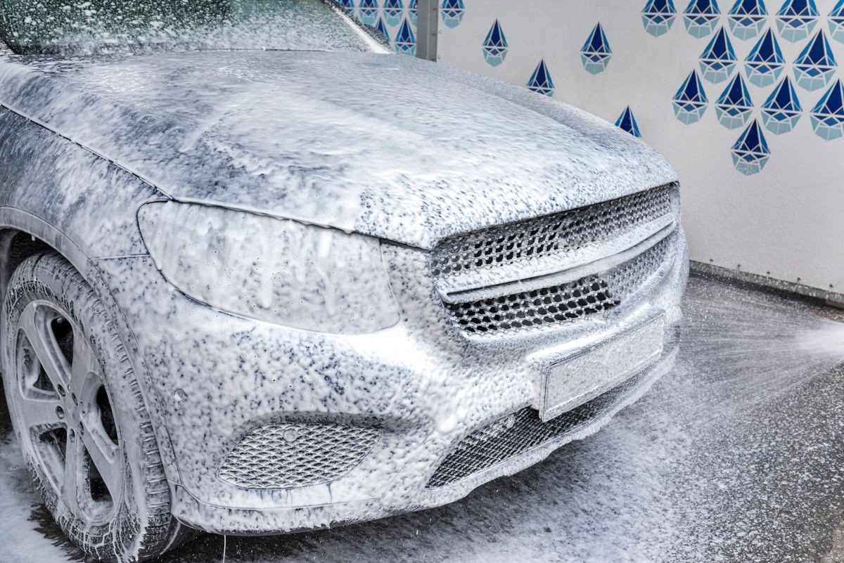 Washing car with soap. Car washing concept. Car in foam.